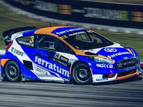 En sportbil i rallydesign kör i hög hastighet på en tävlingsbana.