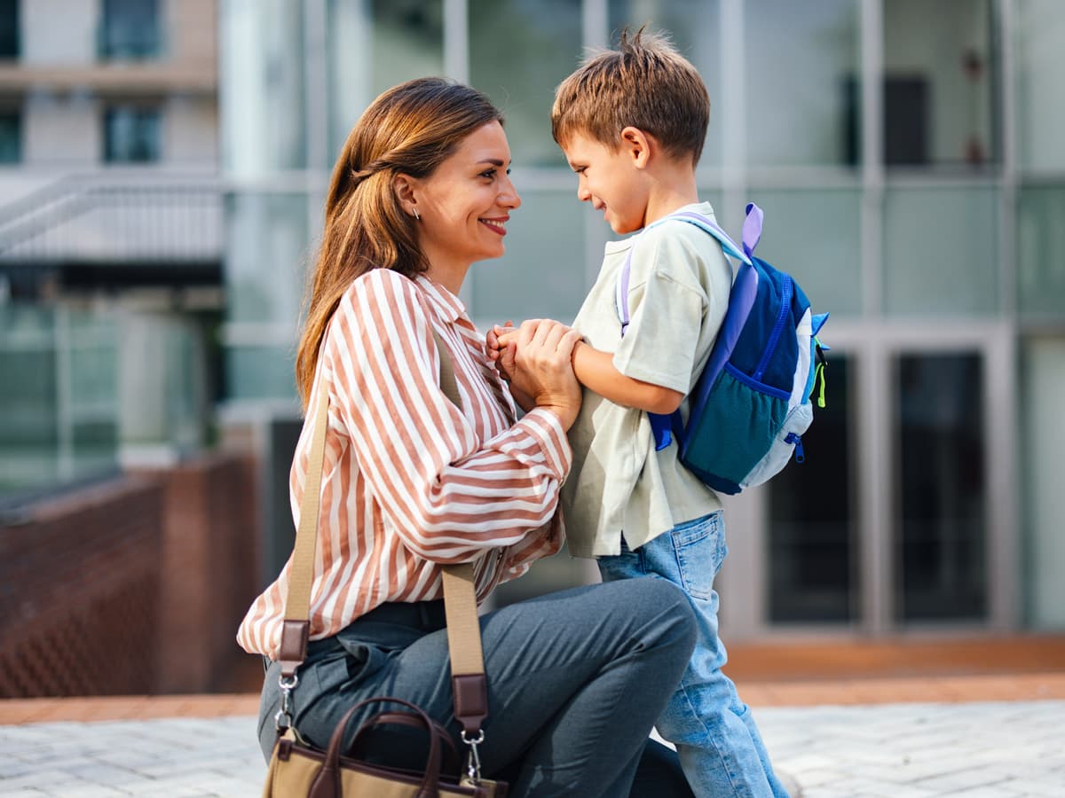 Ett par sitter vid ett köksbord med matvaror, tittar tillsammans på något med glädje.