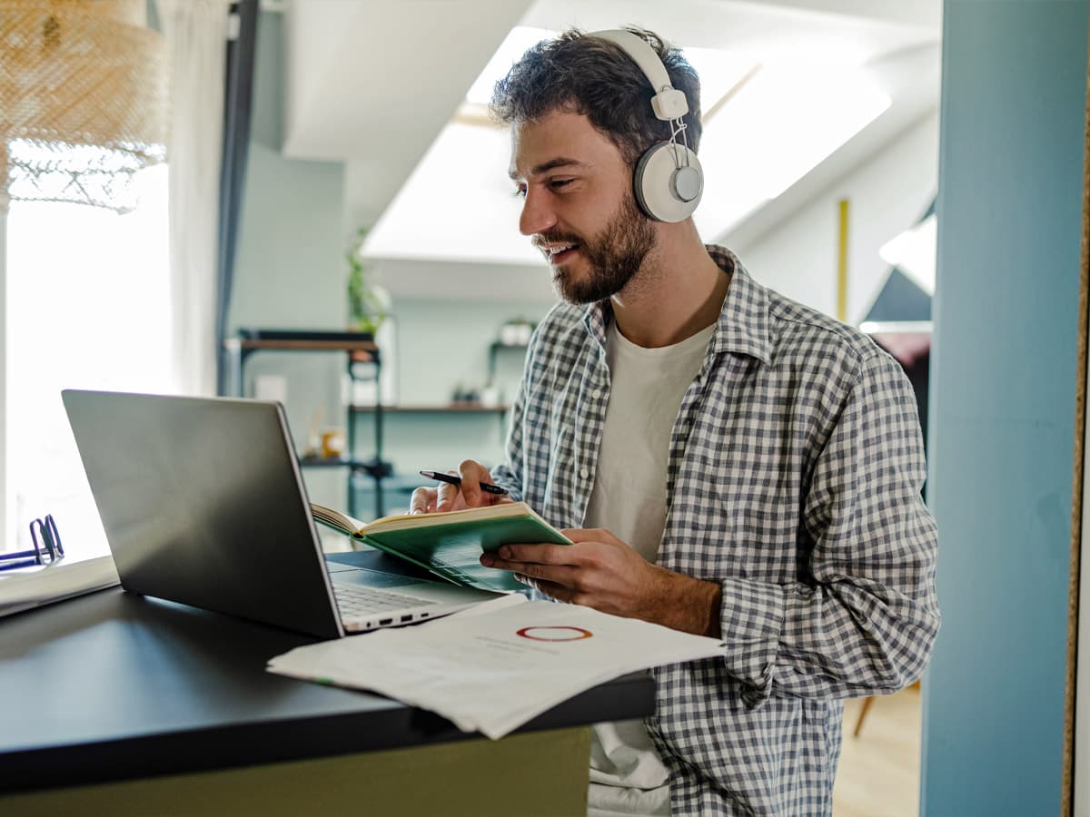 n man i blå tröja håller en telefon mot magen och ser lugn ut mot blå bakgrund.